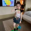 Conjunto de moda estilo coreano para niñas, nuevo modelo verano 2026, falda plisada de manga corta con bloques de color de dibujos animados súper linda para niños