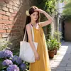 Estilo vacación en la playa verano nuevo vestido de playa con un toque vintage nicho, vestido de tirantes sin mangas con borla amarilla