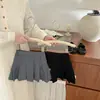 Falda corta plisada de estilo universitario para niñas en verano, elegante, de color liso, cintura elástica, versátil, anti-exposición, media falda, ropa para niños