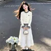 Suéter de punto a cuadros de retazos moderno estilo coreano y falda dulce y linda con lazo - un conjunto de dos piezas para niñas