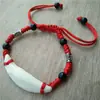 Fabricantes mayoristas de Pig Jing tienen dientes de perro reales pulidos y desinfectados material para joyería DIY para niños Baoma esencia de hueso de Pig Jing