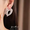 Pendientes de aguja plateada con diseño de corazón hueco incrustado con circonita, pendientes de moda de nicho únicos y elegantes, sensación de lujo ligero y alta gama, venta al por mayor