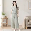 Novo conjunto de moda feminino 2026 com estampa floral em seda gelo, apresentando calças plissadas, de corte solto e curtas, e uma blusa de gola redonda, vendido como um conjunto de duas peças