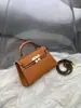 Elegante bolsa Kelly 2026 com fivela de prata e padrão de mão, nova moda feminina, bolsa de mão de segunda geração com fivela dourada, bolsa de ombro e transversal