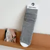 Calcetines de canalé fino a rayas verticales de media caña, calcetines largos grises estilo universitario, combinados con zapatos Mary Jane y calcetines hasta el tobillo