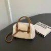 Bolso de mano para mujer estilo commuter, minimalista y sutilmente lujoso para el otoño de 2026, con un diseño afelpado, versátil para llevar al hombro o cruzado.