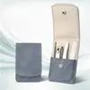 Conjunto portátil roxo de cortadores de unha, um kit de ferramentas de manicure de quatro peças incluindo limpadores de ouvido, pinças e uma lixa de unha, com uma capa de couro para viagem