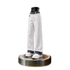 Calça jeans branca para homens, com patchwork de estampa de cobra em cores contrastantes, bainha dobrada, estilo vibe americana, design único e levemente alargada.