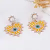 Pendientes de aleación con incrustaciones de perlas y diamantes, con temperamento de moda transfronteriza europea y americana, creativos de lujo ligero, con forma de corazón y ojo de ángel