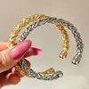Pulseira de punho aberto trançada, apresentando uma textura luxuosa e um design torcido em forma de C, fornecida diretamente pelo fabricante, um design de nicho para joias transfronteiriças
