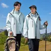 Nueva chaqueta outdoor de estándar nacional para hombres y mujeres, abrigo de senderismo tres en uno a prueba de viento e impermeable, ropa para montañismo y esquí con logotipo personalizado