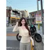 Foto real: Conjunto de duas peças de top de tricô sem alças cor de damasco, estilo puro e desejável de outono, com calça pantalona drapeada com punhos