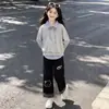 Conjunto de dos piezas para niñas estilo universitario 2026, versátil, con bloques de color a rayas, estampado de gatitos y pantalones casuales