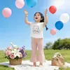 Ropa Infantil Coreana 2026 Verano Nuevo Estilo Tops de Manga Corta para Niñas y Pantalones de Campana Color Sólido Elástico Casual Dulce Conjunto de Dos Piezas
