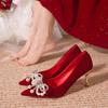 Zapatos de novia nuevos de tacón alto de ante rojo con tacón de aguja, con lazo de diamantes de imitación y punta dorada.
