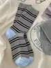 ¡Tan coreano! Es difícil resistirse a estos calcetines gris azulados con dulces lazos de cinta y botones, perfectos para otoño e invierno.