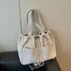 Bolsa tote relaxada em tom bege suave e discreto com uma vibe artística, adequada para estudantes universitárias para compras e armazenamento.