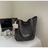 Bolsa de mano tipo tote simple de estilo coreano al por mayor para mujer 2025 Verano Nuevo Gran Capacidad Hombro Único Lona Versátil Bolso de Axila