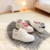Tênis brancos estampados Tongman para mulheres, novo estilo outono 2026, laço com padrão sutil, sola grossa, color block, sapatos casuais para estudantes