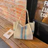 Uma bolsa de praia espaçosa e descontraída, estilo verão, perfeita para férias à beira-mar, com grande capacidade e design de retalhos listrados, adequada para o uso diário.