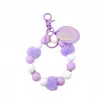 Pulseira de silicone de melhor venda transfronteiriça, chaveiro de pulso com pingente, etiqueta de madeira, pompom, pulseira de contas de silicone, acessório de chave
