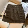 Foto real cor café estilo retrô Maillard saia jeans feminina nova chegada outono 2026 cintura alta bolso workwear saia curta