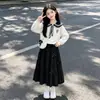 Conjunto de dos piezas para niña: una sudadera con cuello de muñeca y una falda midi de moda con lazo, perfecta para principios de otoño, adecuada para la escuela
