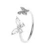 Anillo elegante con cuatro mariposas y diamantes, estilo popular en Internet, ligero y lujoso, con apertura para el dedo índice.