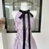 Top de Algodão com Elastano, Cor Roxo Violeta Refletor de Luz, Gola Alta, Manga Curta, Detalhe de Babados e Laço, Estampa de Uva com Gelo, Bloqueio de Cores, Saia