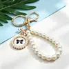 Llavero de Perlas y Lazo Estilo Coreano Pulsera de Placa Redonda de Metal Colgante para Coche Estuche para Teléfono Móvil con Cuentas para Mujer Colgante para Bolso