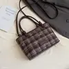 Bolsa transversal de ombro único estilo coreano para outono, bolsa tote diária com pingente, novo estilo para o trabalho para mulheres, design doce e fofo 2026, com estampa xadrez e motivos de desenhos animados adoráveis