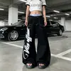 Jeans streetwear leve estilo americano com estampa de graffiti de asas e costura aparente, calça de algodão unisex de perna larga, corte curvo, multi-bolsos, comprimento até o chão