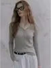 Camiseta única y de nicho de punto de sarga gris con cuello en V y manga larga para mujer, top casual de otoño de alta gama ajustado con hombros normales