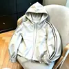 Colección Otoño 2026: Chaqueta corta elegante y versátil con patchwork bordado y capucha, diseñada para figuras petite, que ofrece un ajuste casual y relajado.