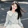 Moletom de Manga Longa com Gola de Boneca Moda para Crianças Grandes Conjunto de Duas Peças Novo para Primavera e Outono Meninas Saia Curta Doce Fofa com Laço