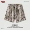 Shorts Largos Casuais com Estampa Camuflada por Transferência Térmica e Forro de Fleece - Roupas Masculinas Outono/Inverno 2025 - Linha High Street Europeia e Americana - Calças Casuais