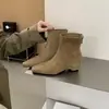 Botines de gamuza de punta cuadrada y tacón de cuña en una paleta de colores Maillard, con cremallera trasera, combinados con una falda y jeans de pierna ancha