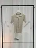 Elegante y profesional, este cárdigan de punto de manga corta con cuello polo para mujer es un nuevo estilo de verano que estiliza y tiene un diseño de hombros rectos.