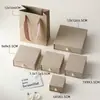 Caja de joyería de lujo ligero con asa de perla texturizada y diseño acanalado, textura de caja dura, adecuada para pendientes, pulseras y empaque de regalo; disponible en stock