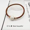 Nueva cuerda para el pelo simple de perlas, diadema, banda elástica, cuerda para la cabeza con cubierta de cuero para mujer, versión coreana de Banda Elástica al por mayor, anillo para el pelo de alta elasticidad