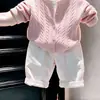 Ropa infantil coreana 2026 colección otoño/invierno nueva: conjunto de suéter rosa de punto trenzado, cárdigan de punto y pantalones casuales blancos para niños y niñas