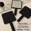Espejo negro de estilo ins coreano con mango simple, espejo de retoque de alta gama conveniente, espejo de mano de maquillaje pequeño lindo
