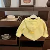 Novo Modelo da Tongxingyuan Mostra o Amarelo Frango Clareador! Jaqueta Suéter de Tricô Grossa com Capuz e Pompons para Bebê Menina Coreana