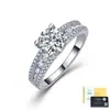Anel de moissanita em prata S925 para mulheres, apresentando uma cravação de quatro garras com uma pedra principal redonda, uma cravação mista de duas fileiras com pedras de destaque e um design leve e luxuoso. Direto da fábrica