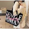 Bolsa Versátil Ins para Commuter Bolsa Tote de Lona Grande Capacidade com Letras para Mulheres Nova Bolsa de Lona de Nicho Tailandês 2025