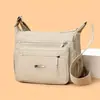 Bolsa transversal durável em tecido Oxford para mães, com múltiplos bolsos com zíper, design portátil e alças largas nos ombros, perfeita para o uso diário.