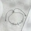 Joia de Mão em Ouro Real Banhado com Zircônia Inlaid de Luxo Leve para Mulheres Toque de Alto Padrão Concha Natural Trevo de Quatro Folhas Pulseira Ajustável com Fio de Puxar