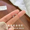 Aretes de tornillo de flor pequeña hueca de plata 999 para el cuidado de perforaciones, aretes elegantes y sofisticados, aretes de diseño de nicho para mujer