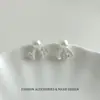 Aretes de aguja de plata s999, nudo de mariposa hueco, aretes de perla, nuevo estilo 2026, dulces y elegantes, aretes de lujo ligeros para mujer
