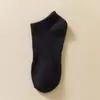 Medias clásicas en blanco y negro y gris para hombre y mujer, de color liso, con cintura antideslizante, de tubo medio, para deportes, informales, transpirables, de algodón.